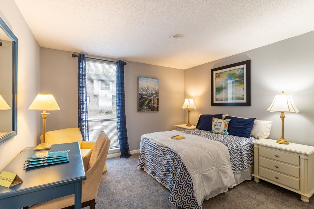 a bedroom with a bed and a desk and a window