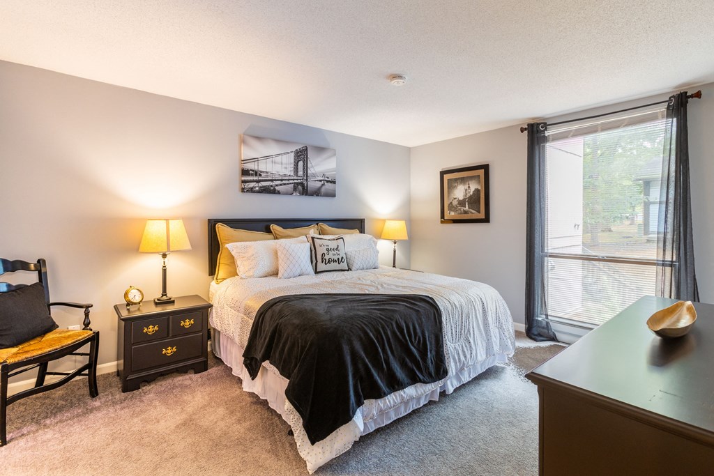 the master bedroom has a king sized bed and a large window