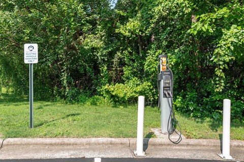 An electric vehicle charging station is located next to a sign that says "ELECTRIC VEHICLE CHARGING ONLY".