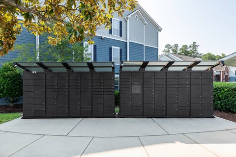 A large black structure with a roof is situated on a concrete slab.
