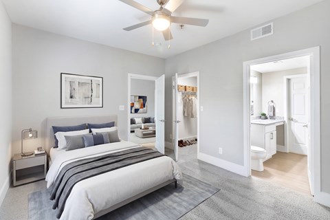 A bedroom with a large bed and a ceiling fan.