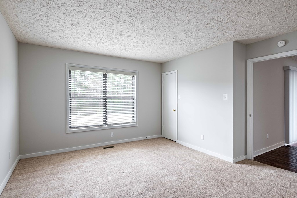 an empty room with a window and a door