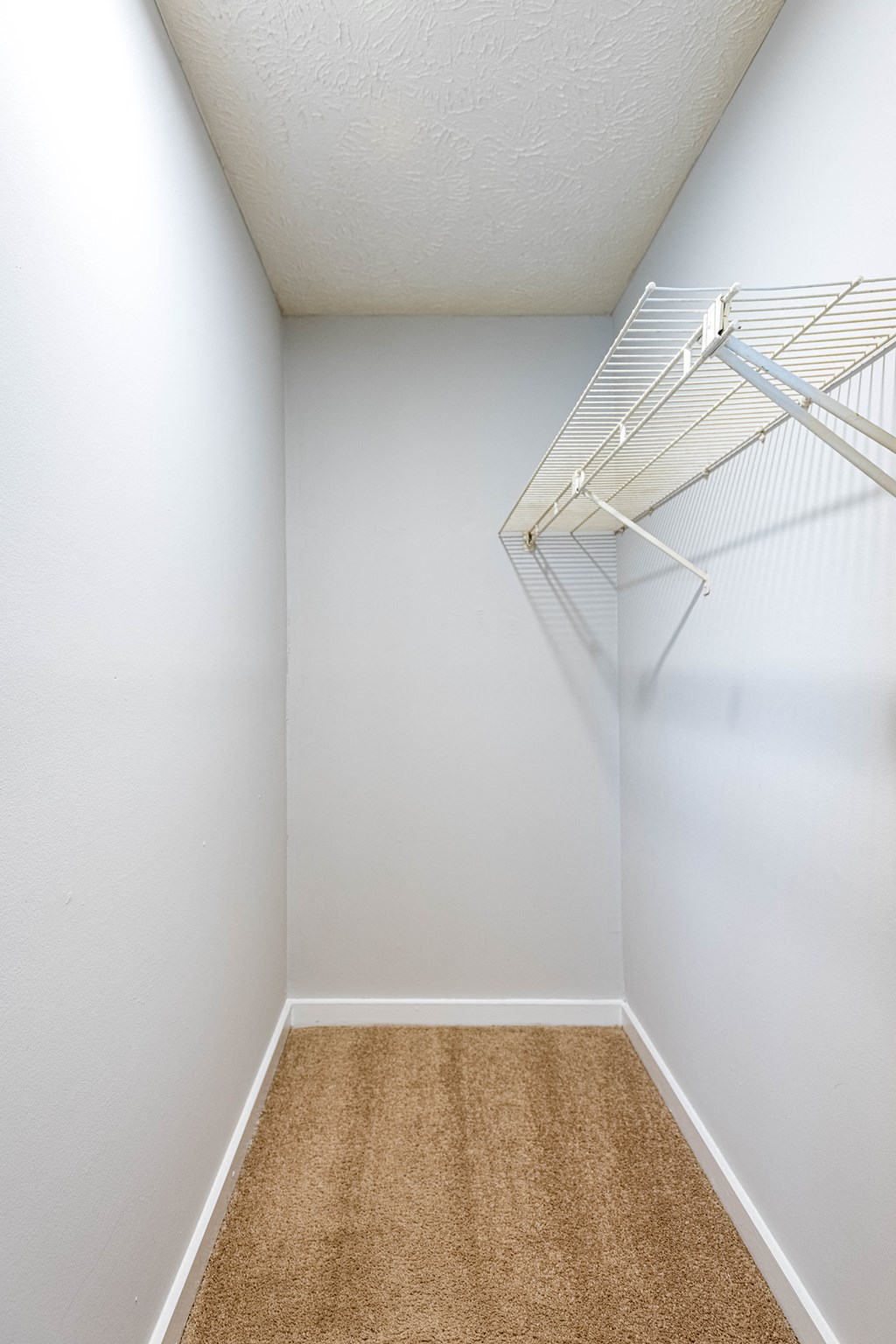 an empty bedroom with white walls and a white closet