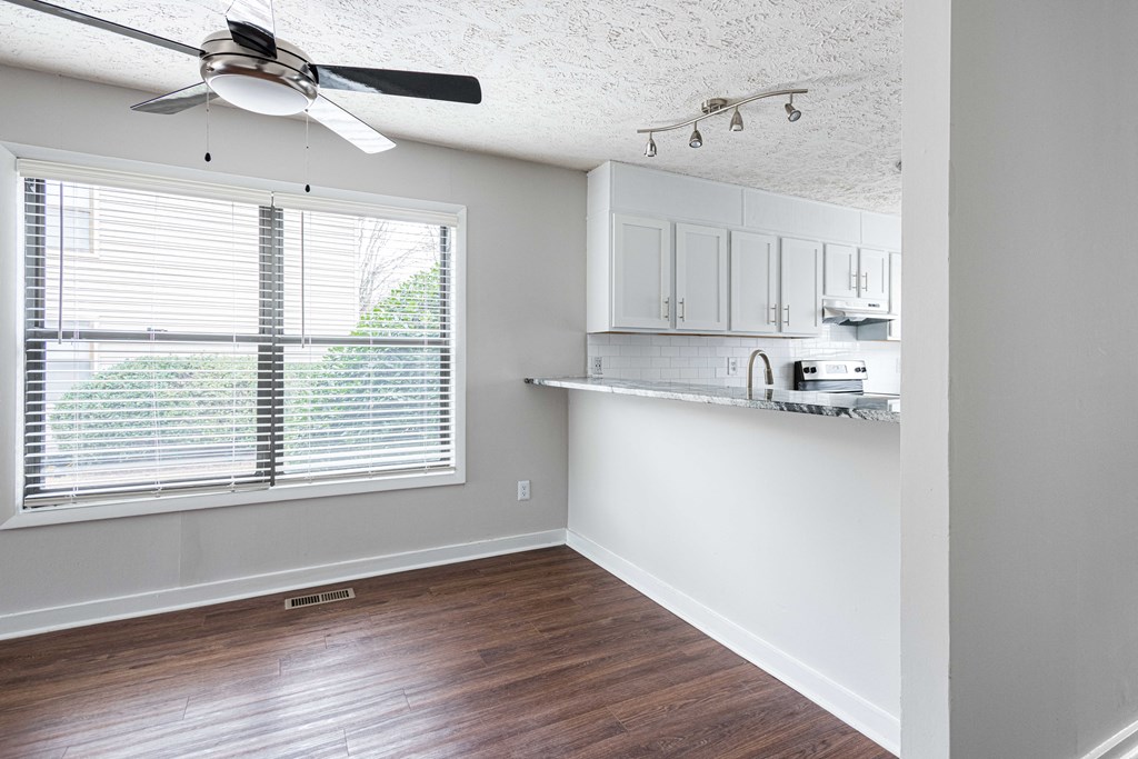 an empty living room and kitchen with a large window