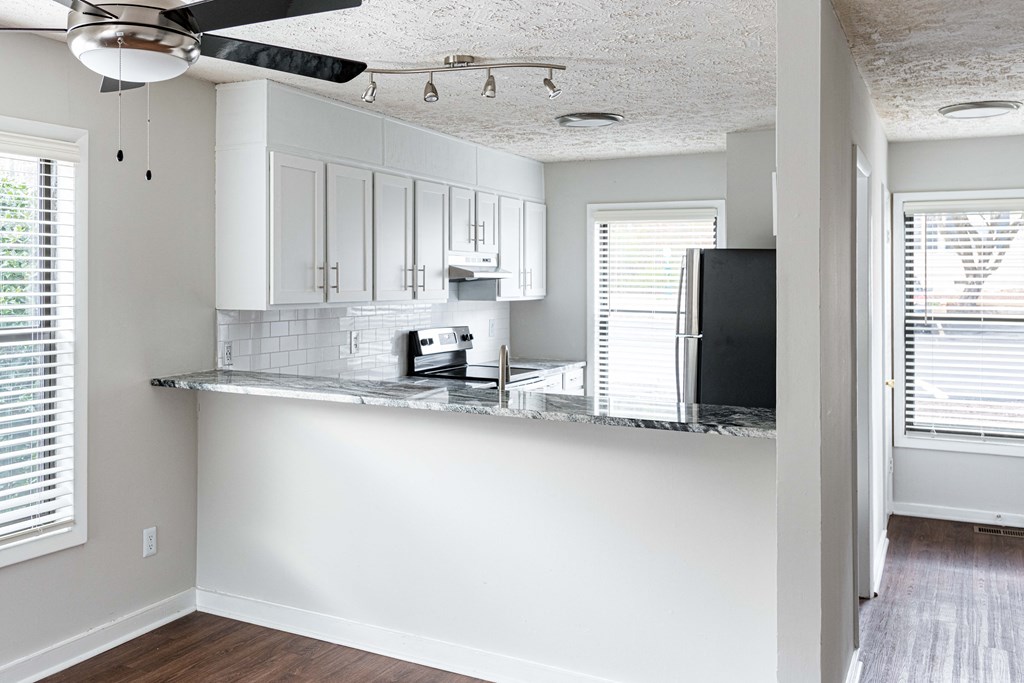an empty kitchen with white cabinets and a counter top