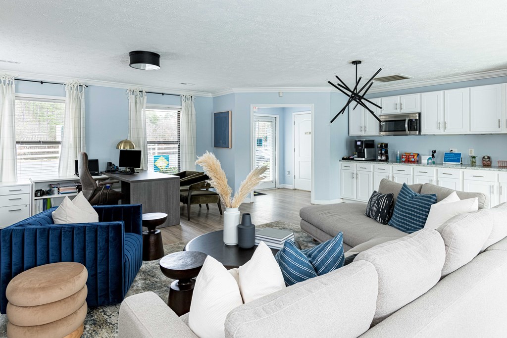 a living room with blue and white furniture and a kitchen