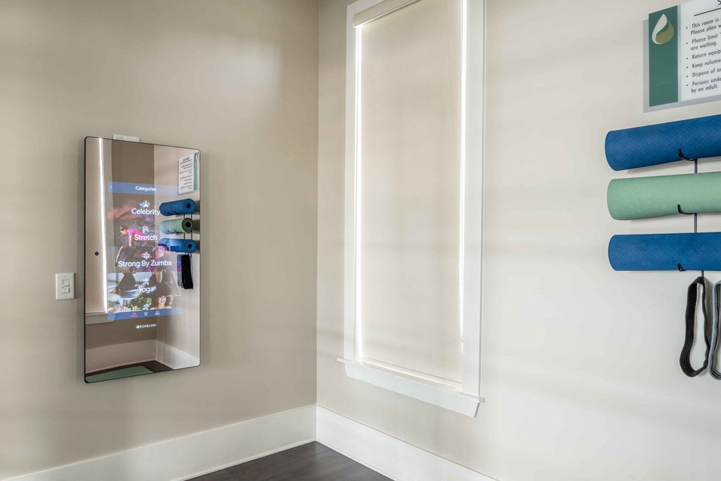 a hallway with a mirror and a closet with blue and green towels