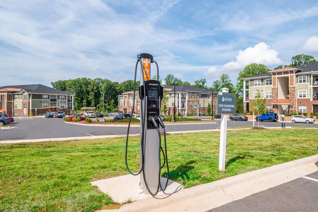 a gas station on the side of the road with apartments in the background