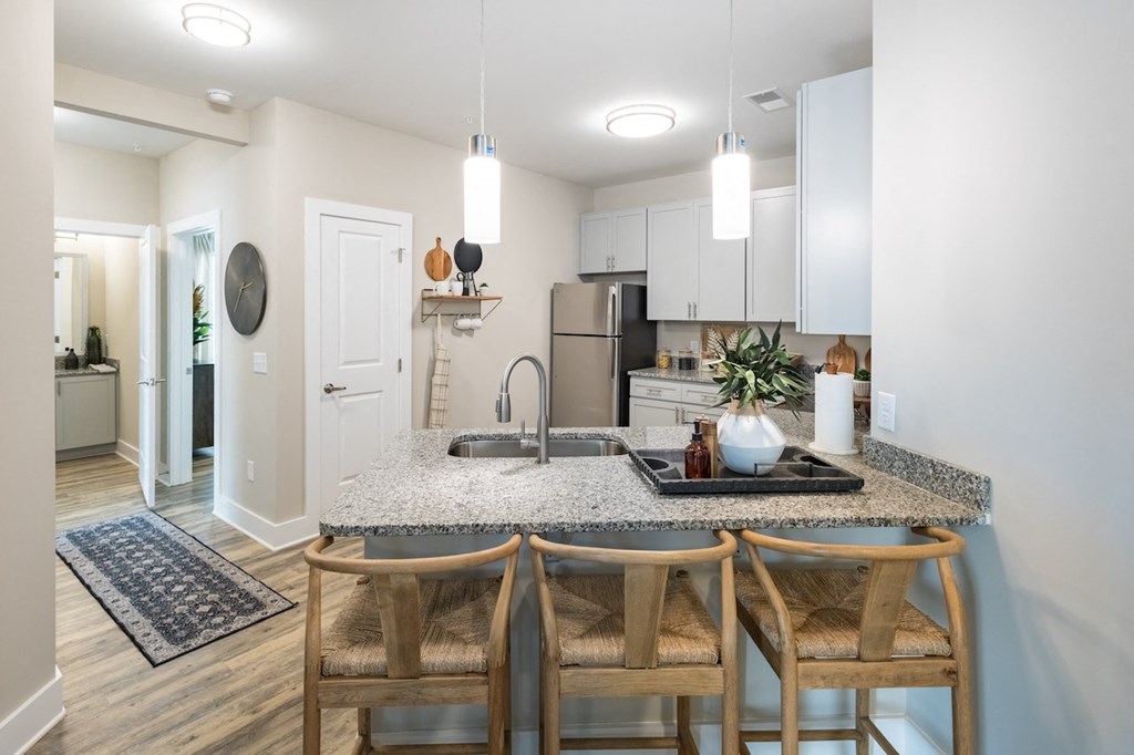 a kitchen with white cabinetry and a granite counter top
