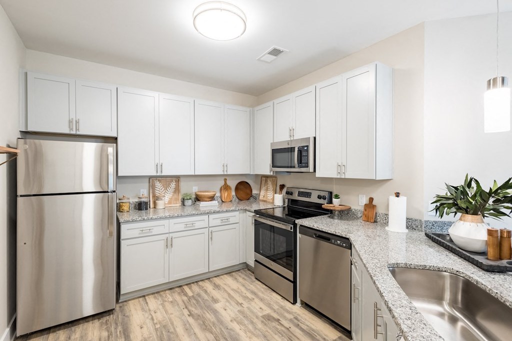 a modern kitchen with white cabinets and stainless steel appliances