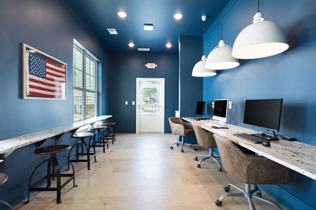 a room with blue walls and a long counter with computers on it