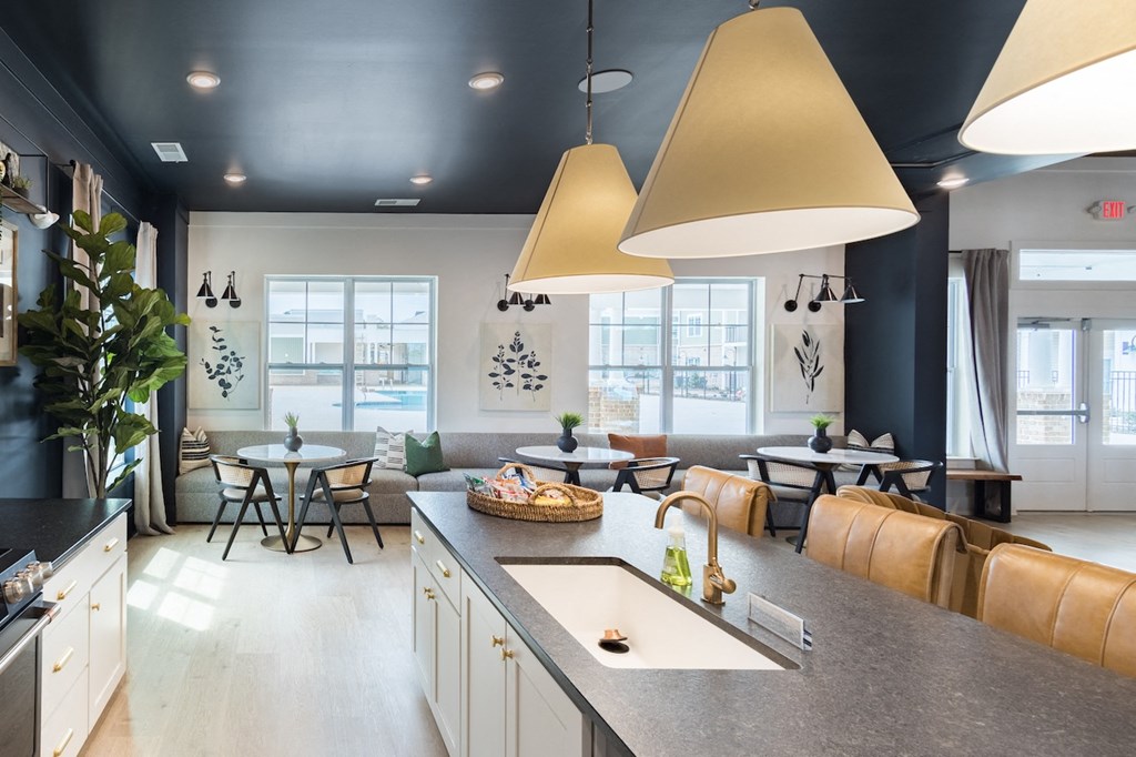 a kitchen with a large center island next to a living room with a couch and tables