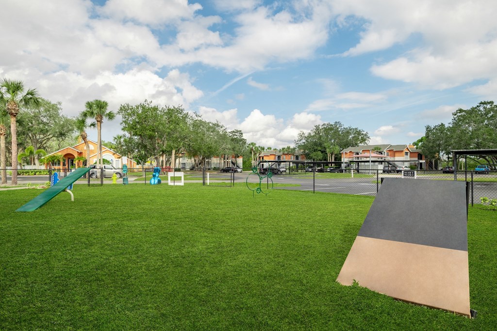a playground with a slide and trampoline at the whispering winds apartments in pearland,