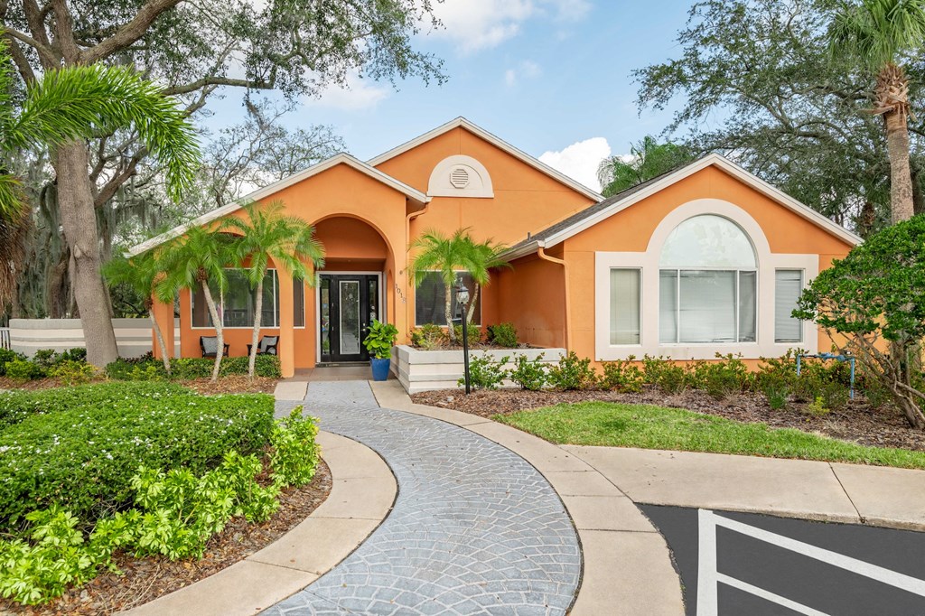 a home with an orange exterior and a walkway leading to the front door