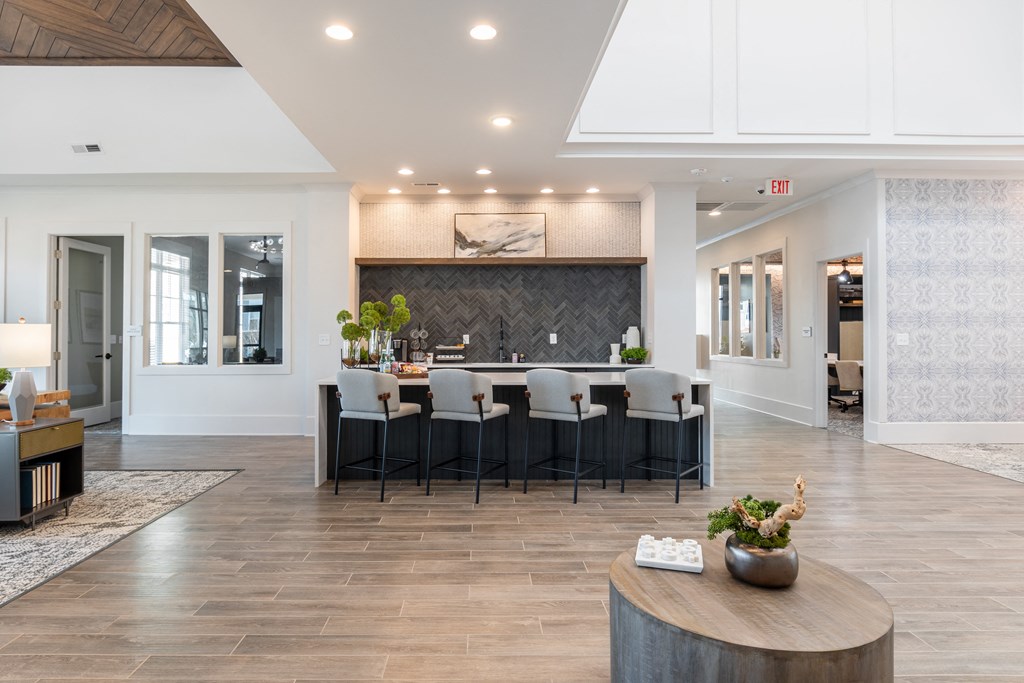 the gathering room has a large table with chairs in front of a bar with chairs