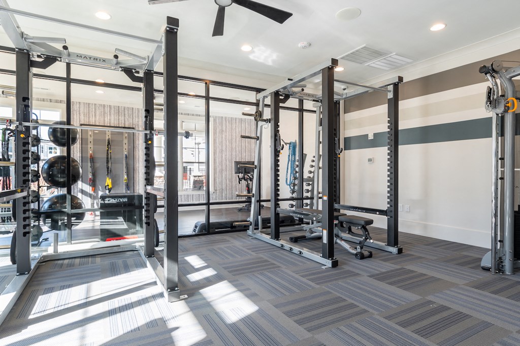 a home gym with weights machines and a ceiling fan