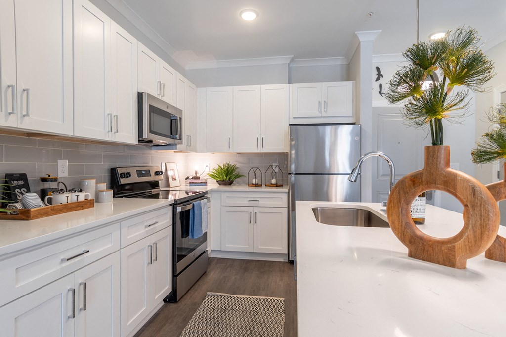 a large kitchen with white cabinets and stainless steel appliances