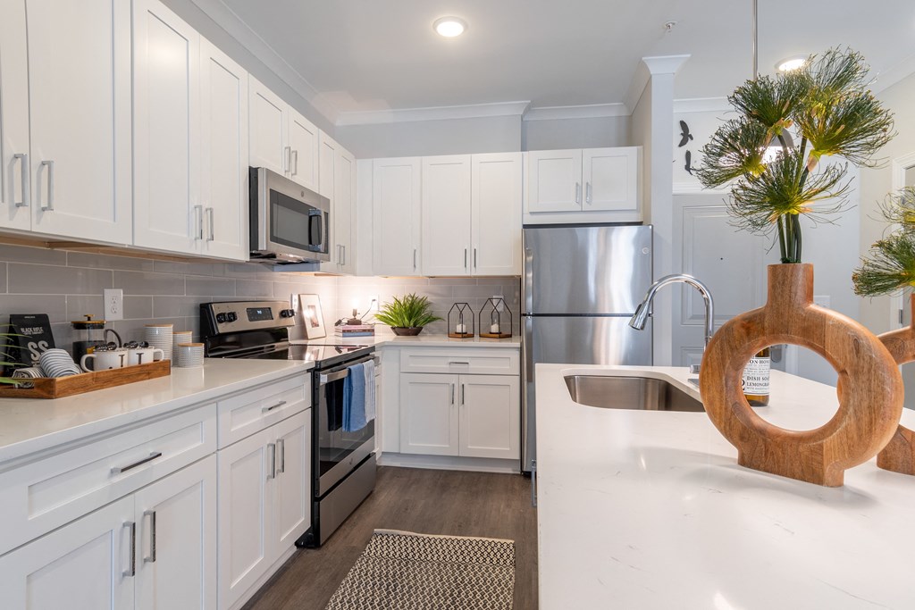 a large kitchen with white cabinets and stainless steel appliances