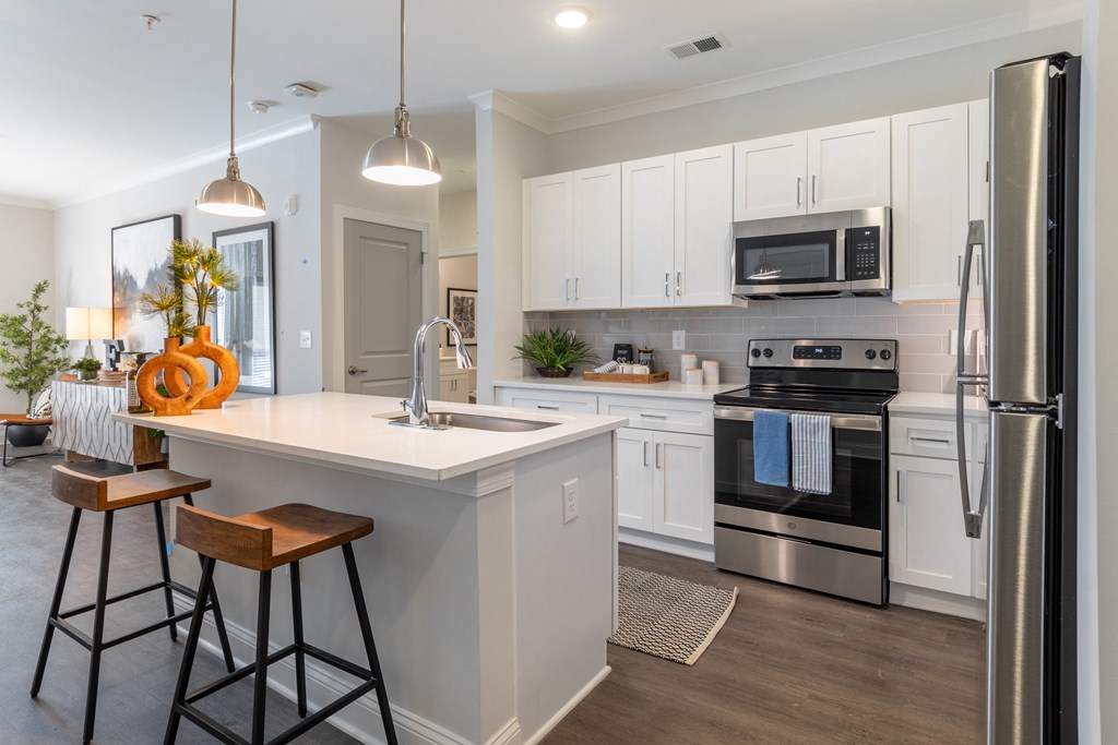 a kitchen with a large island and stainless steel appliances