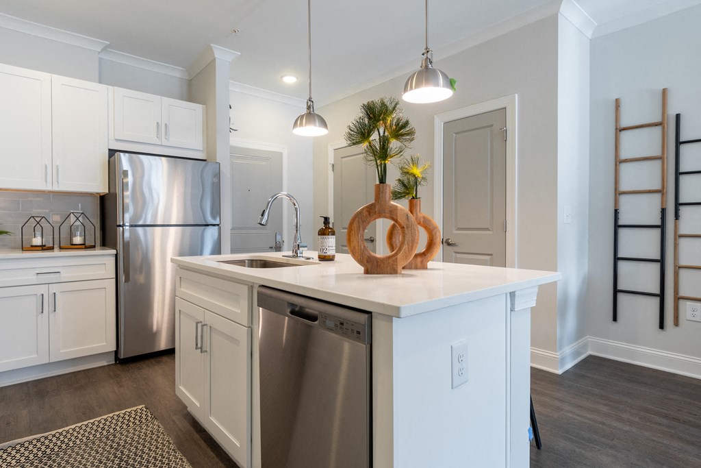 a kitchen with a large island and a stainless steel refrigerator