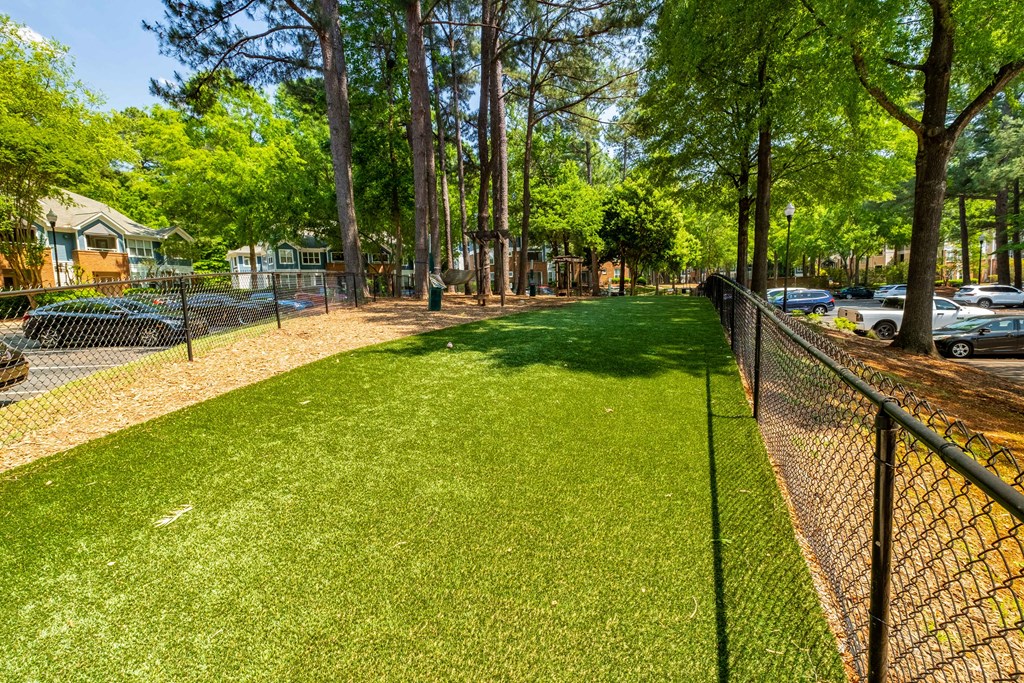 a fenced in dog park next to a chain link fence