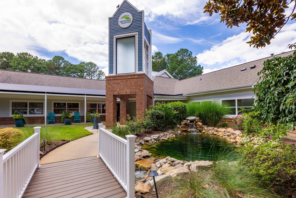 a courtyard with a pond and a building with a clock tower