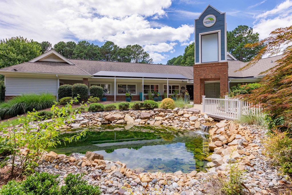 a garden with a pond in front of a house