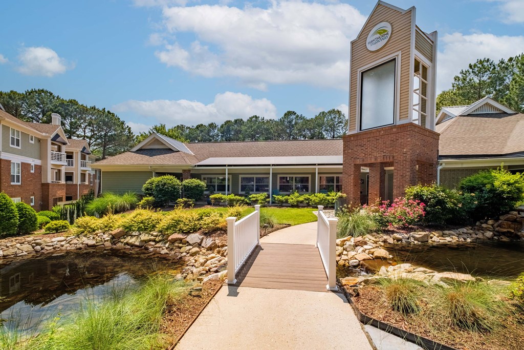 a walkway with a bridge leading to a building with a clock tower