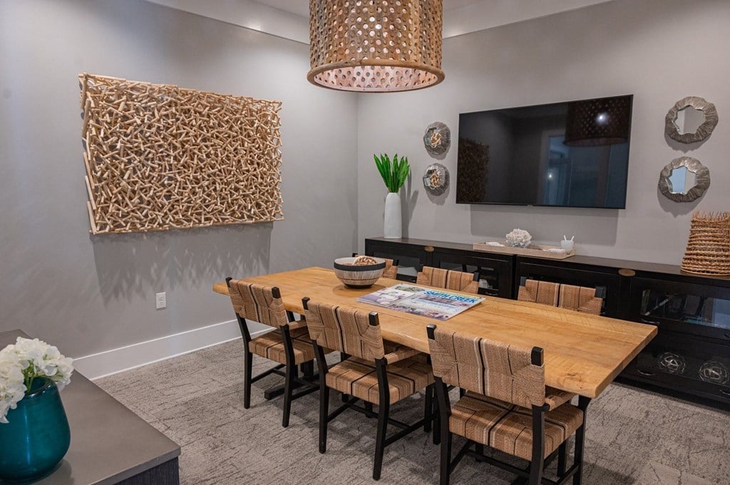 a dining room with a wooden table and chairs and a television