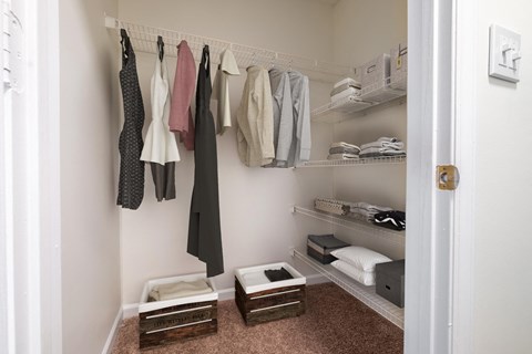 A small walk in closet with shelves and baskets at Amelia Village apartments in Clayton, NC.