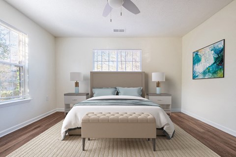 A bedroom with a large bed, a ceiling fan, and a painting on the wall.