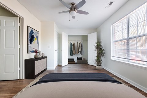 A bedroom with a bed and a ceiling fan at Amelia Village apartments in Clayton, NC.