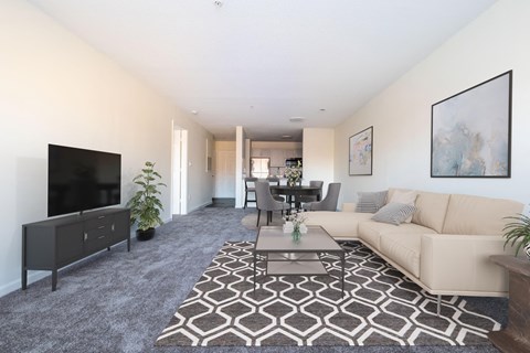 A living room with a couch and a table and a tv at Amelia Village apartments in Clayton, NC.