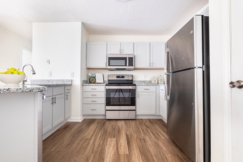 A renovated kitchen with stainless steel appliances and white cabinets at Amelia Village apartments in Clayton, NC.