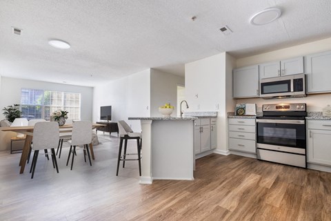 A kitchen with white cabinets and a dining table with chairs.