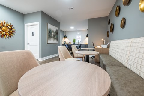 A common area with a wooden table and chairs at Amelia Village apartments in Clayton, NC.