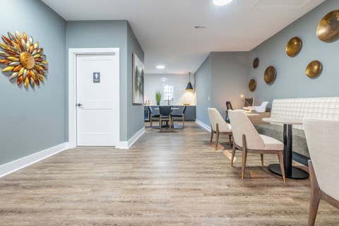 A common area with blue walls and white furniture at Amelia Village apartments in Clayton, NC.