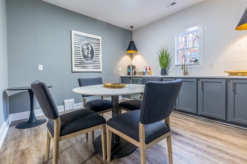 A common space with a white table and black chairs at Amelia Village apartments in Clayton, NC.