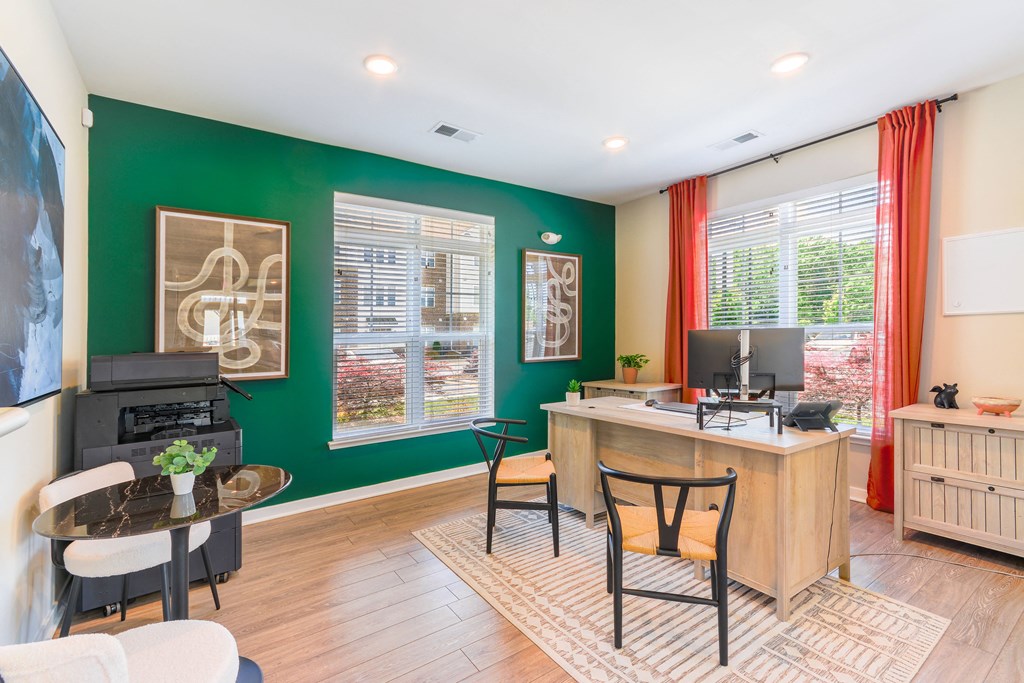 a living room with a green wall and a desk with a computer
