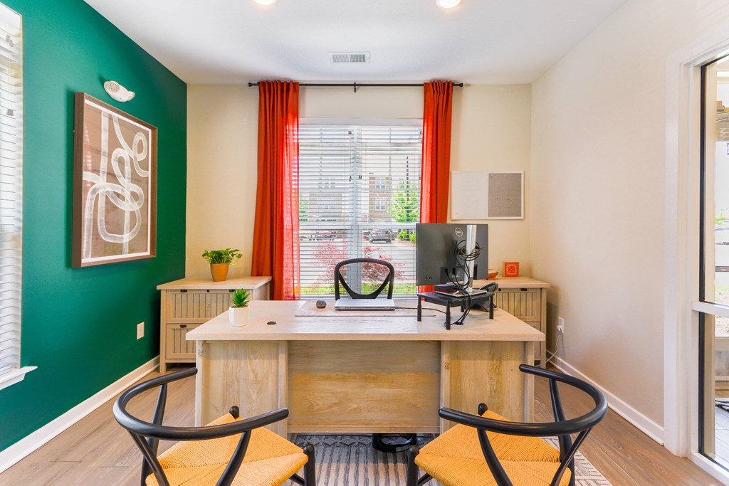 a home office with a green wall and a desk with a computer