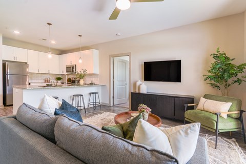 a living room with a couch and a chair and a kitchen