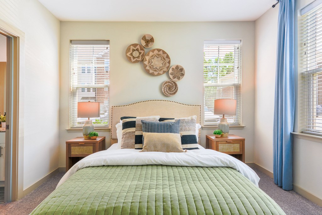 a bedroom with a bed and two windows