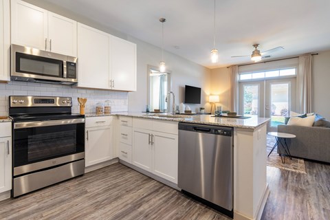 A modern kitchen with stainless steel appliances and white cabinets.