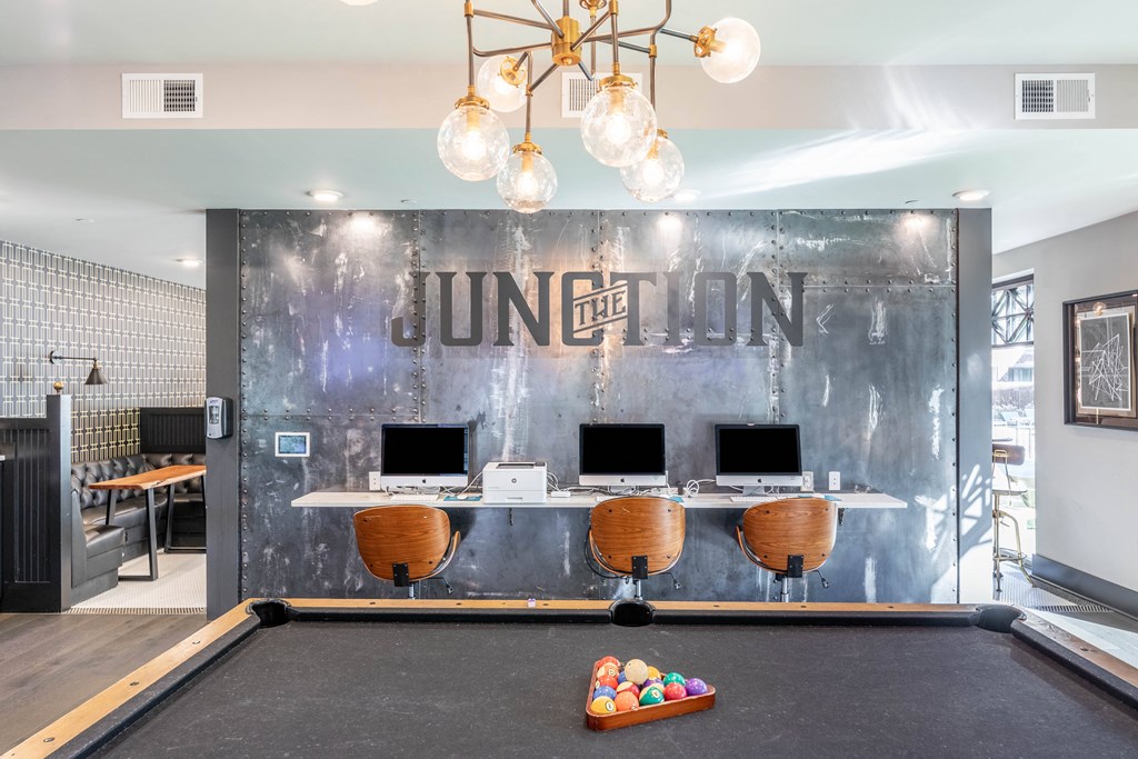 a game room with a pool table and a mirrored wall with thelonious monk