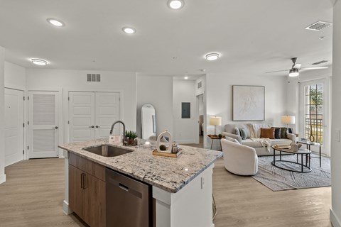 an open kitchen and living room with a couch and a table