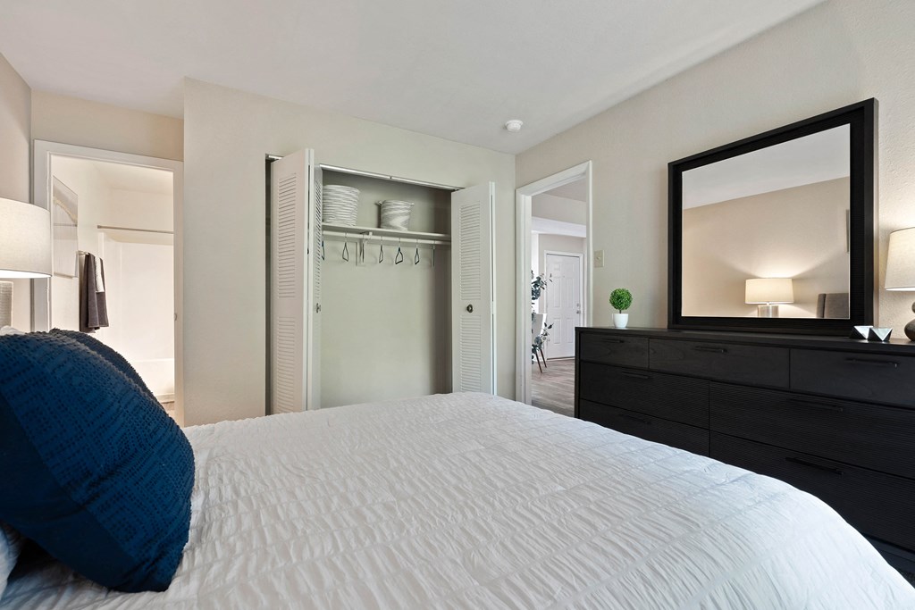 a bedroom with a large white bed and a mirror at Hawthorne at Oak Ridge in Greensboro, NC