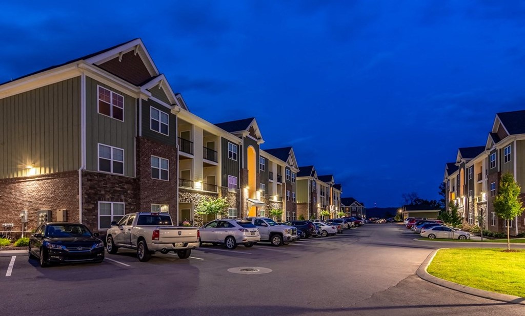 a row of apartment buildings on a street at night