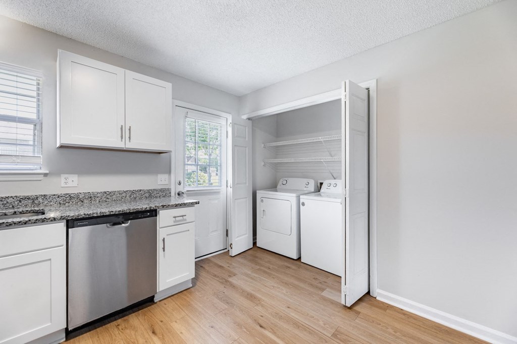 A kitchen with white cabinets and appliances.