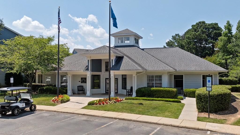 a white house with two flags and a golf cart in front of it