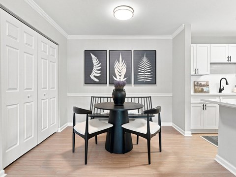 A dining room with a table and chairs.